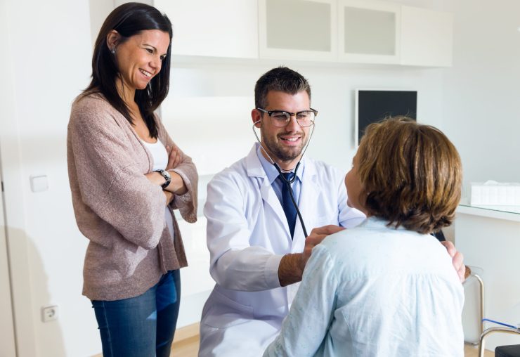 Portrait of mother with her daughter being examined with stethoscope by pediatrician.
